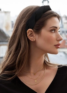 Detail showing elegant black braided headband with gold layered heart necklaces for women