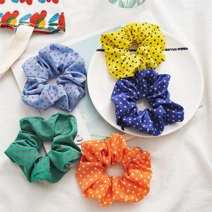 Detailed set of five colorful polka dot scrunchies in blue, yellow, green and orange fabric