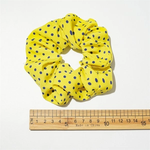 Chic yellow and blue polka dot scrunchie with 10cm diameter measurement on white background
