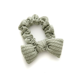 Green knitted bow hair scrunchie with soft ribbed texture and plush padded design