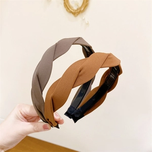 Detail of twist braided headbands in brown and camel fabric with non-slip inner teeth