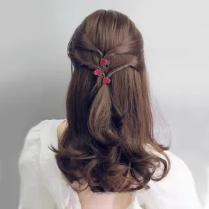 Macro view of matte red heart-shaped hair clips styled on long wavy brown hair