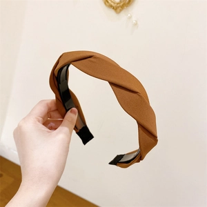 Detail of brown braided headband showing twill fabric texture and non-slip inner teeth