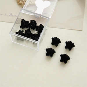 Close-up of black velvet star mini hair clips in a transparent storage case for hair styling