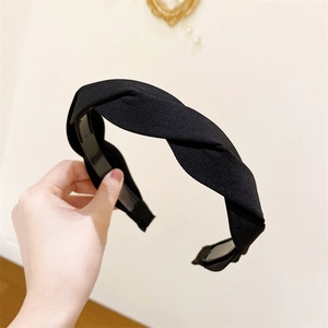 Detail of black twisted fabric headband featuring inner anti-slip teeth for secure styling