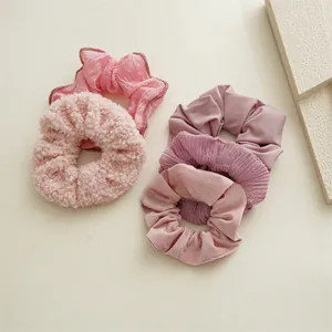 Détail de chouchous roses montrant des textures en laine d'agneau, tricot et tissu plissé