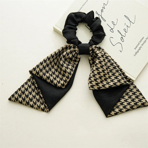 Detail of elegant houndstooth ribbon scrunchie with chic black and white fabric texture