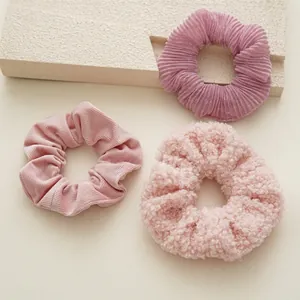 Ensemble de trois chouchous roses avec textures en velours et tissu plissé