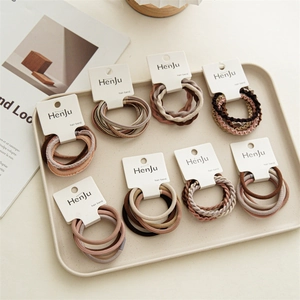 Detailed view of elastic hair bands in earth tones with various woven textures on white card