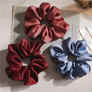 Three-piece set of satin scrunchies in burgundy, dusty pink, and grey blue colors
