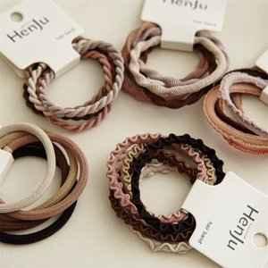 Set of 5 elastic neutral hair ties with diverse textures on branded white card