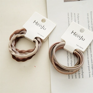 Detailed view of elastic hair bands in brown and champagne tones on decorative book