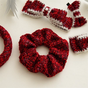 Detail of red and black tweed scrunchies and bow clips with subtle sequin textures