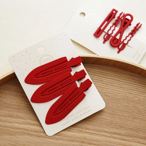 Détail des barrettes à cheveux rouges mats et pinces bec de canard sur cartes de vente