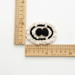 Handmade crochet hair clip with black bow and white pearls on white background