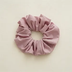 Texture détaillée d'un chouchou rose en tissu côtelé avec élastique interne doux