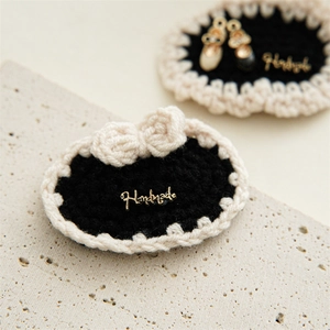 Detail view of handmade crochet hair clip with lace border and gold metal plaque