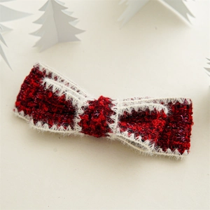 Detail of red tweed bow hair clip with metallic threads and white faux fur trim for Christmas
