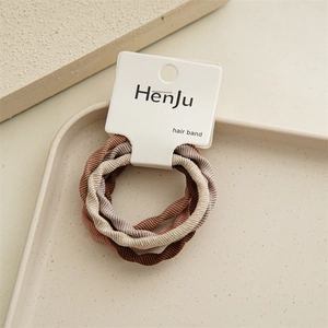 Detailed view of elastic hair bands in earthy tones on premium display packaging