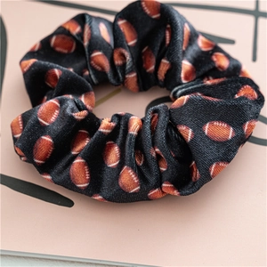 Detalle de coletero de terciopelo negro con estampados de fútbol americano en la tela suave