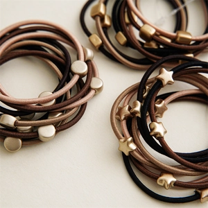 Set of 10 neutral tone elastic hair ties with matte gold geometric star and round charms