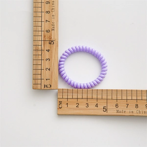 Detailansicht eines 4,5 cm lila Spiral-Haargummis mit Linealmessung auf Weiß