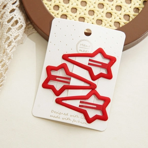 Lot de trois barrettes rouges en forme d'étoile en métal mat sur carte de présentation