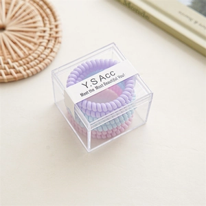 Detail von 6-teiligen Spiral-Haargummis in Pastellfarben in einer klaren Box