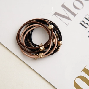 Detailed close-up of brown hair ties with golden star charms on a magazine background
