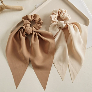 Detail of elegant caramel brown and beige silk scrunchies with long ribbon streamers