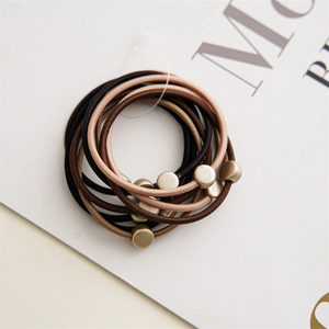 Detail of coffee-toned elastic hair ties with matte metallic circular bead accents