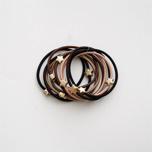 Detail showing elastic hair ties in coffee tones with golden star charms on white background