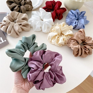 Detailansicht der weichen Satin-Textur und des Falten-Designs der großen Scrunchies