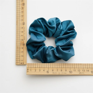 Detail showing elegant peacock green satin scrunchie with 10cm diameter measurement