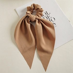 Close-up of caramel scrunchie with long ribbons showing twill fabric texture and detail
