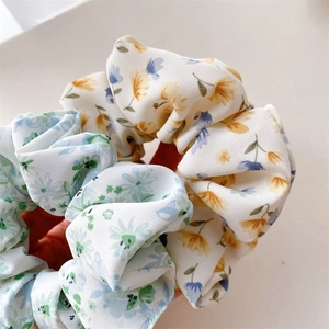 Détail de chouchous en tissu avec motifs floraux en bleu clair et couleurs crème