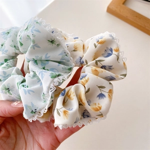 Gros plan détaillé de chouchous à fleurs avec bordure en dentelle blanche et tons pastel