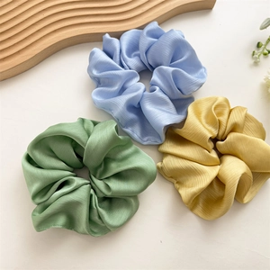 Trois chouchous élégants surdimensionnés en bleu, vert et jaune avec texture satinée