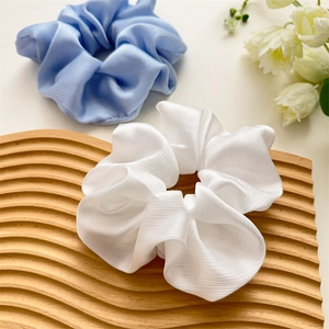 Détail de chouchous élégants en mousseline plissée bleue et blanche de grande taille