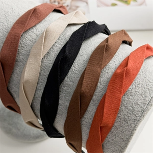Detail showing five colors of twisted fabric headbands in premium textured linen material