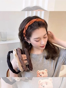 Detailed view of criss-cross woven fabric headband showing high-top textured pleats
