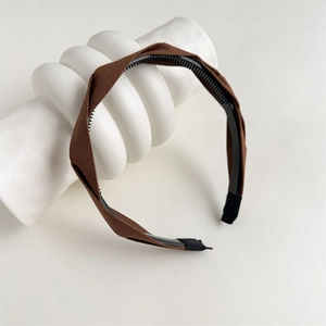 Detail view of brown fabric twist headband showing inner non-slip teeth for grip