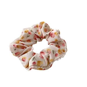 Chouchou floral avec bordure en dentelle et motif de fleurs roses sur fond beige crème