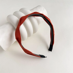 Detailed texture of orange pleated fabric headband with non-slip inner teeth