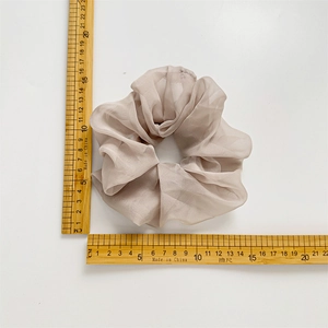 Chouchou géant en soie champagne avec plis doux mesurant 12 cm sur fond blanc