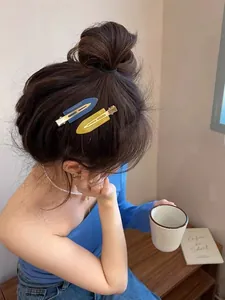 Détail de pinces à cheveux mates bleues et jaunes portées pour un look élégant
