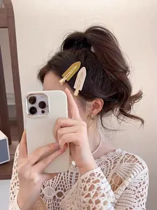 Détail de barrettes ovales crème et vert olive portées pour une coiffure latérale