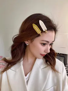 Mannequin portant des barrettes ovales jaune et crème pour un style minimaliste