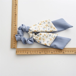 Floral print bow hair scrunchie with long ribbons in blue fabric measuring 20cm long