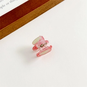 Gros plan d'une mini pince à cheveux marbrée rose avec ressort argenté et acrylique